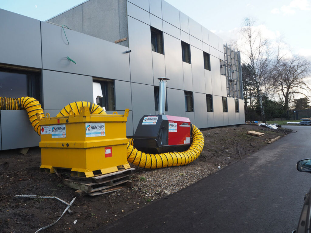 Mobiele verwarming van 150 kW met mazouttank en gele luchtslangen aan de brandweerkazerne in Luik
