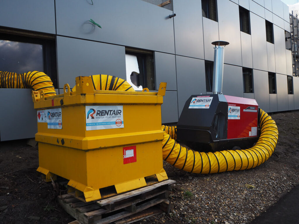 Brandstoftank van 1000 liter op een pallet naast het rode warmtekanon bij de brandweerkazerne