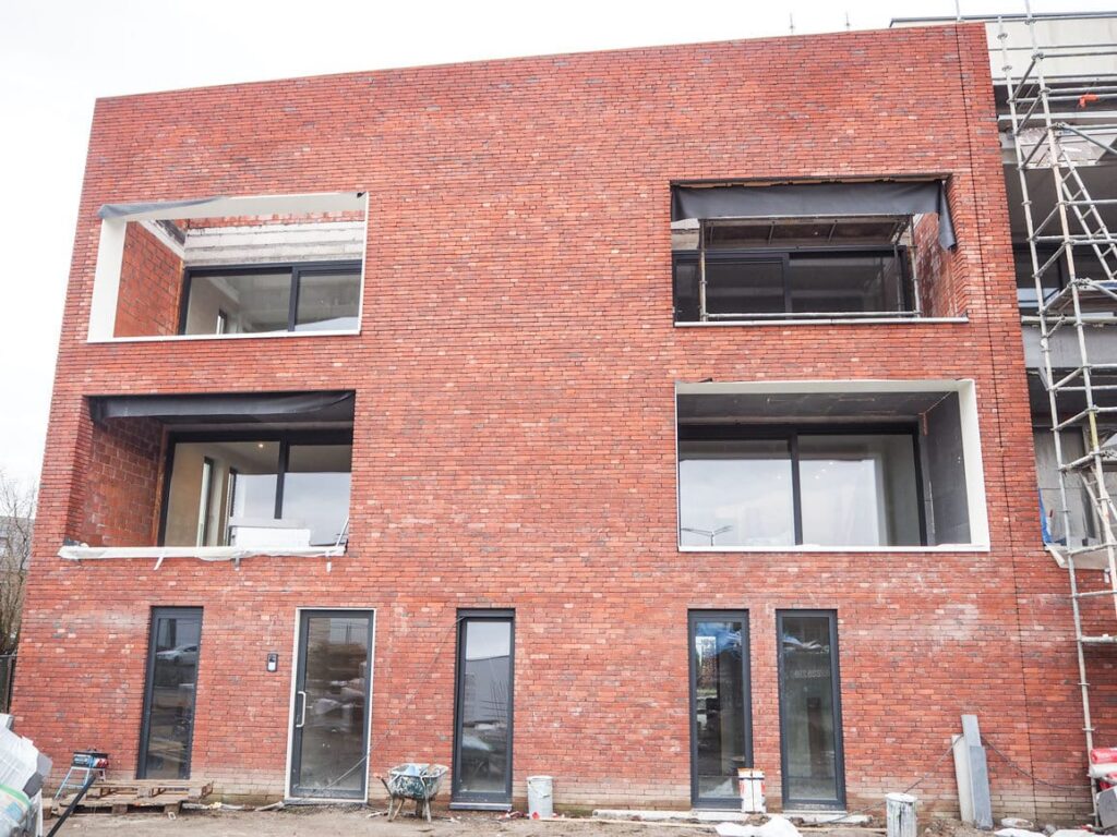 Appartementsgebouw in rode baksteen met stelling in Wuustwezel, tijdelijk elektrisch verwarmd