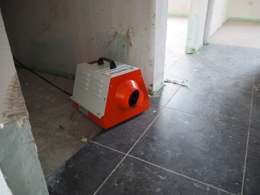 Elektrisch verwarmingstoestel van 3 kW naast een deuropening in een appartement met kale muren