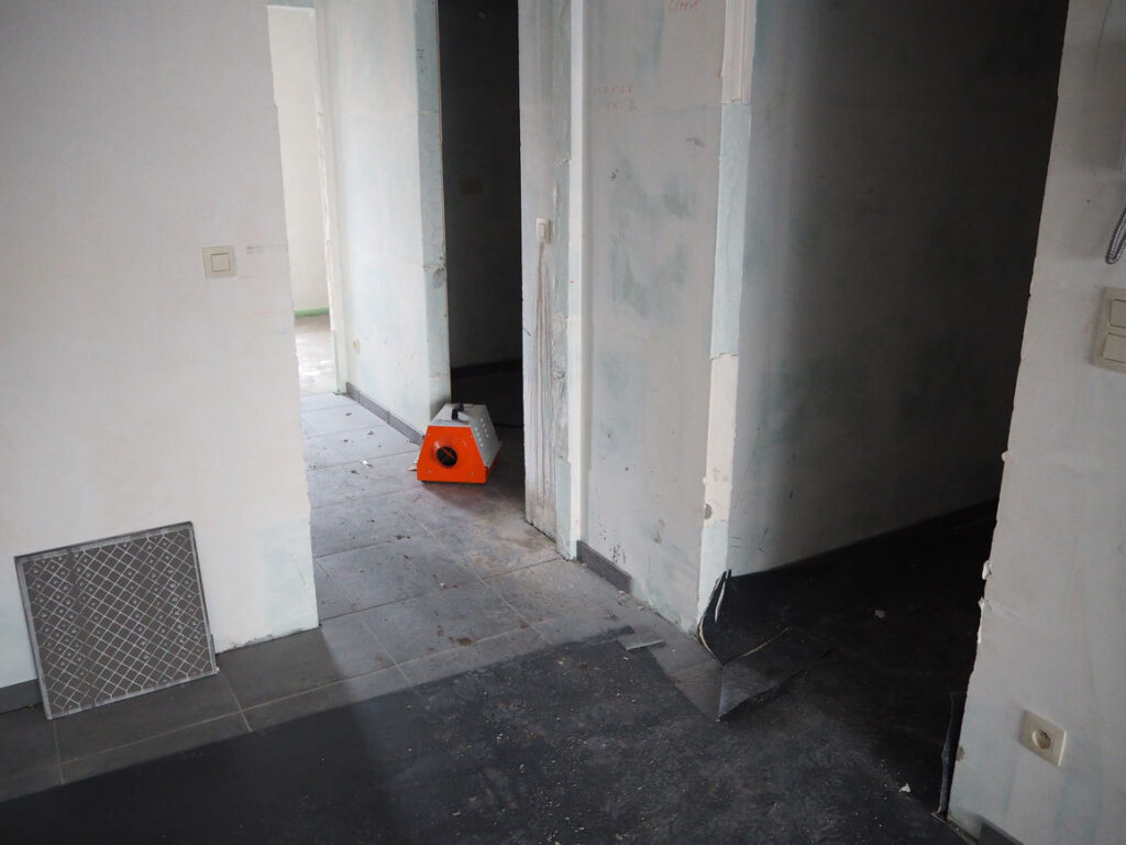 Elektrisch verwarmingstoestel achteraan in de gang, gezien vanuit een kamer van het appartement